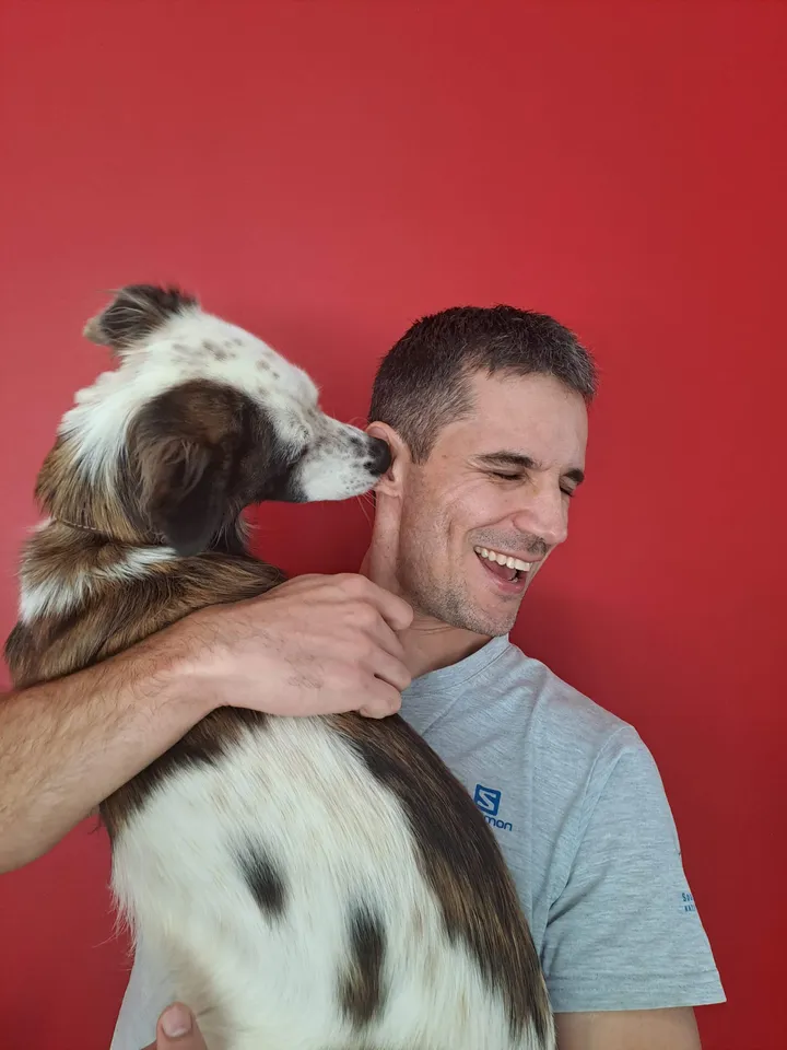 JP laughing while Lilly, his collie cross, licks his ear
